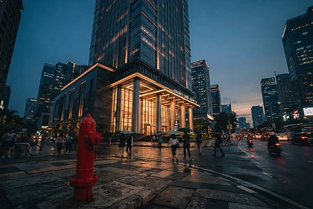 Hydrant pillar merah di depan gedung bertingkat saat senja